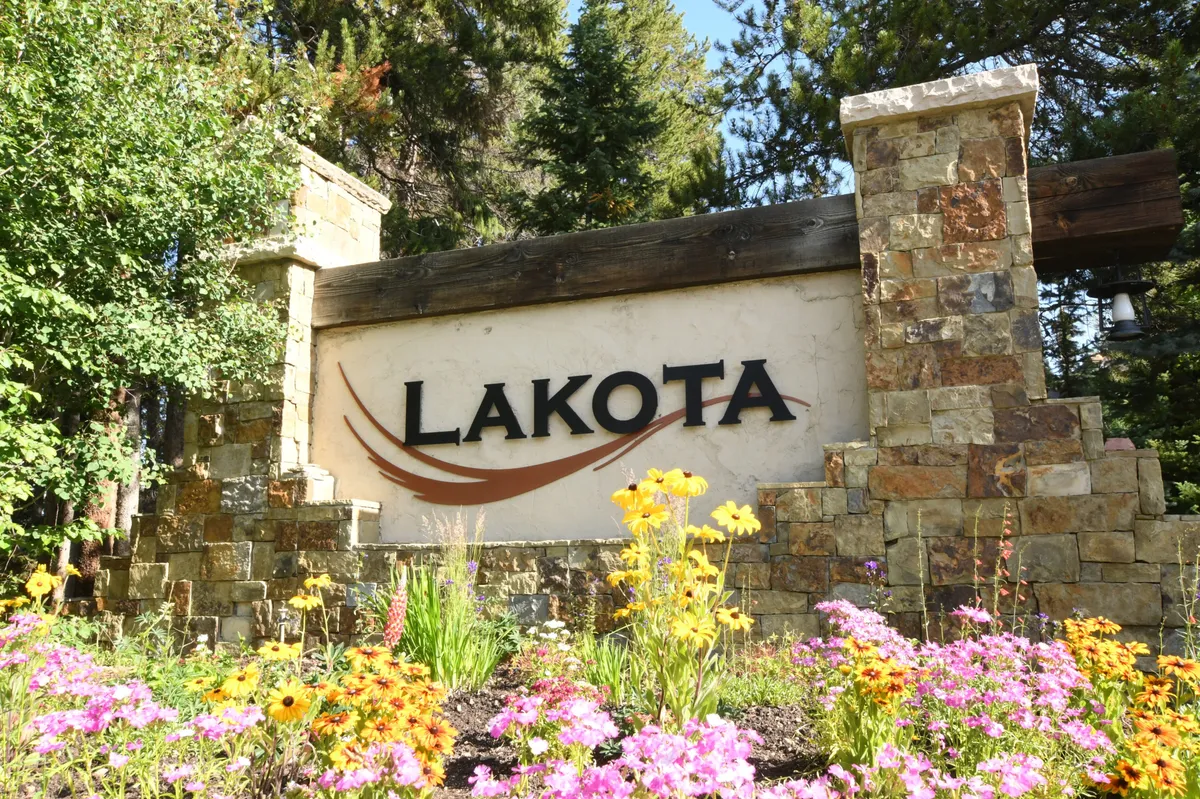 A welcoming exterior view with prominent signage, beautifully maintained flower beds, and a rustic stone wall. This spot is perfect for arriving guests and offers a setting for photography or community gatherings.